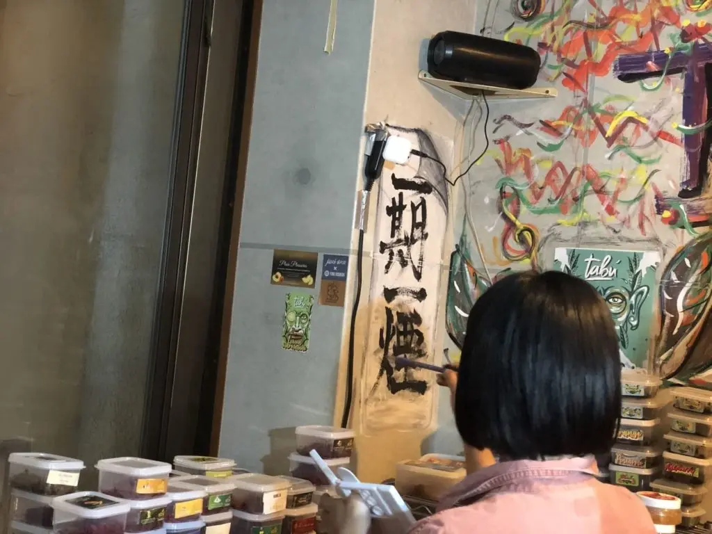 壁に描かれた習字と女性