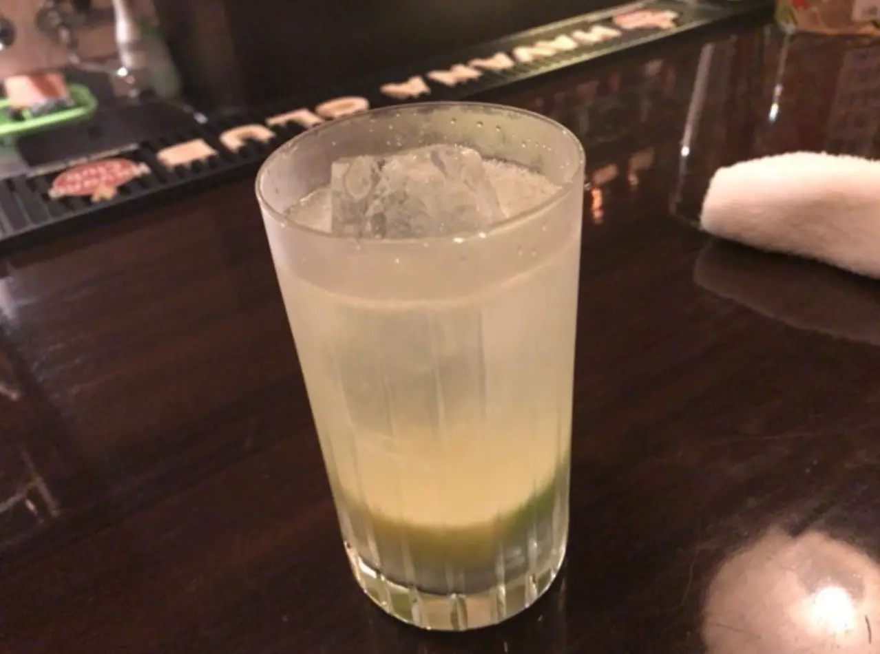 カウンターの上に柑橘系の果実が入ったカクテル