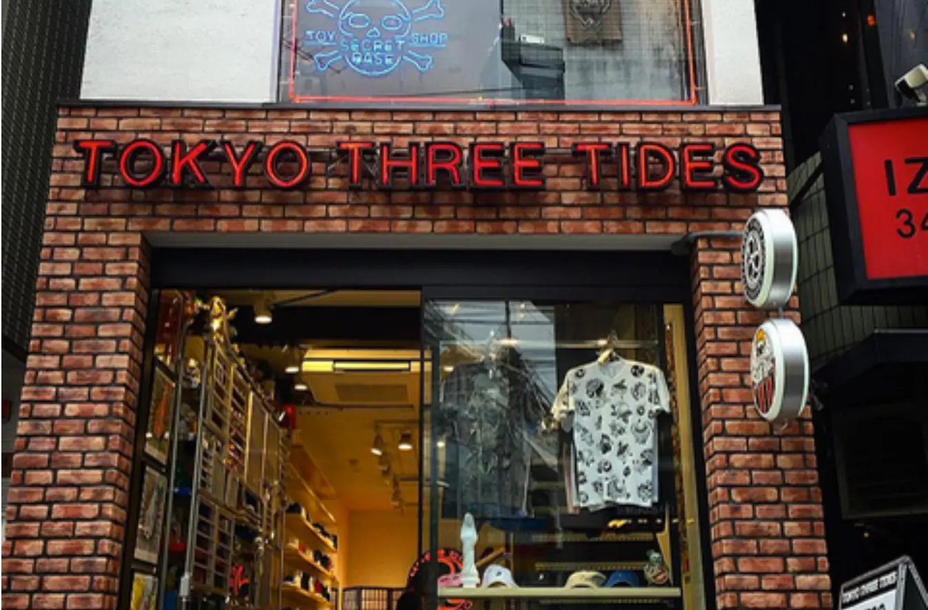 店名の書かれた赤いネオンの下のショーウィンドウがありTシャツなどが掛けられている